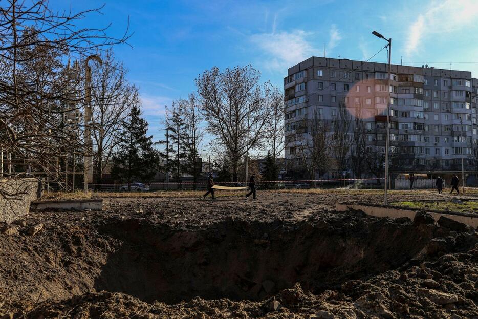 ロシアの攻撃で地面にできた大きな穴＝5日、ウクライナ南部ヘルソン（ロイター＝共同）