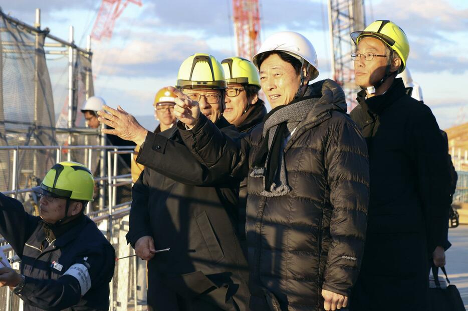 万博会場予定地を視察する西村経産相（右から2人目）＝2日午後、大阪市の夢洲