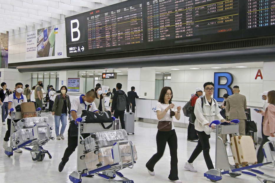 訪日観光客らでにぎわう成田空港の国際線到着ロビー＝6月