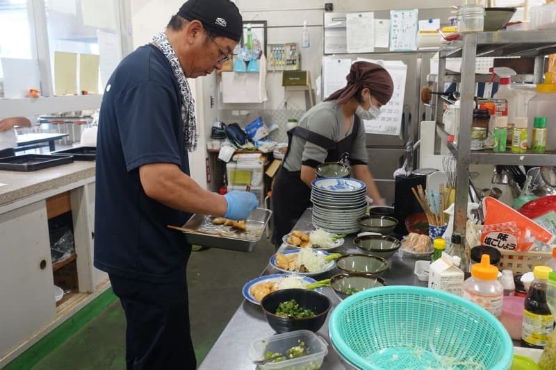 香川県立三本松高校の学食で、チキン南蛮定食をつくる藤本丈晴さん