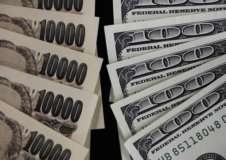 1万円札と100ドル紙幣＝2011年8月（ロイター＝共同）