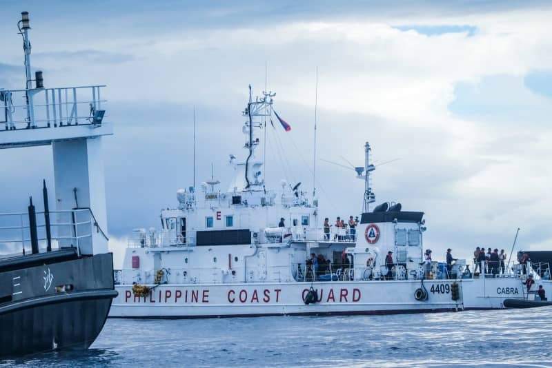 １１月１０日、南シナ海・アユンギン礁への補給任務の際、中国の海上民兵の船（左）に追尾されるフィリピン沿岸警備隊の巡視船（共同）