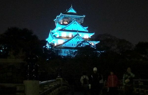 [写真]青色に輝く大阪城を見て写真を撮る人も多かった＝14日午後8時ごろ、大阪市中央区で
