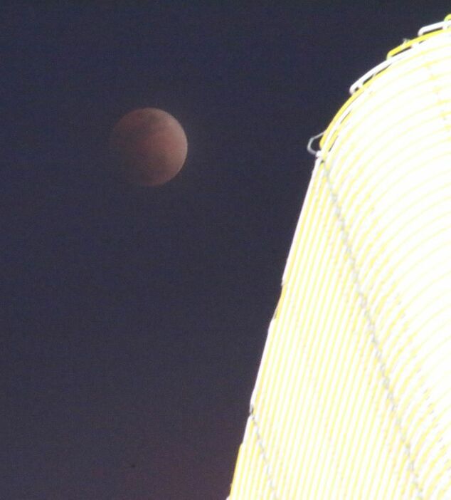 [写真]大阪市中央区からも赤黒く輝く「皆既月食」を観測できた＝31日午後10時ごろ、道頓堀で（撮影：柳曽文隆）