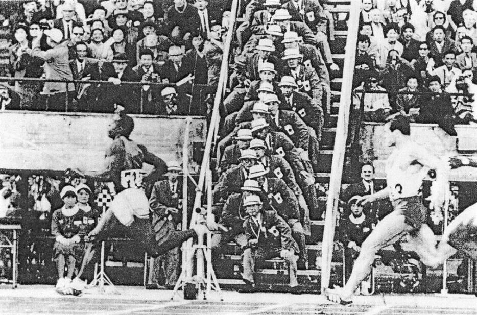 1964年の東京五輪では電子計時とともに従来の「手動計時」も実施された。ゴールライン真横に設置されたひな壇に縦に並んでいるのがストップウオッチをもった24名の計時員