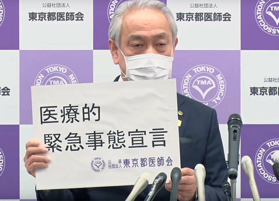 「医療的緊急事態宣言」のボードを掲げる東京都医師会の尾崎治夫会長＝6日午後4時すぎ