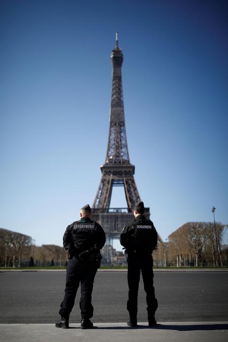 エッフェル塔の前で警戒に当たる警官ら。市民の姿は見えない。3月23日撮影（写真：ロイター/アフロ）