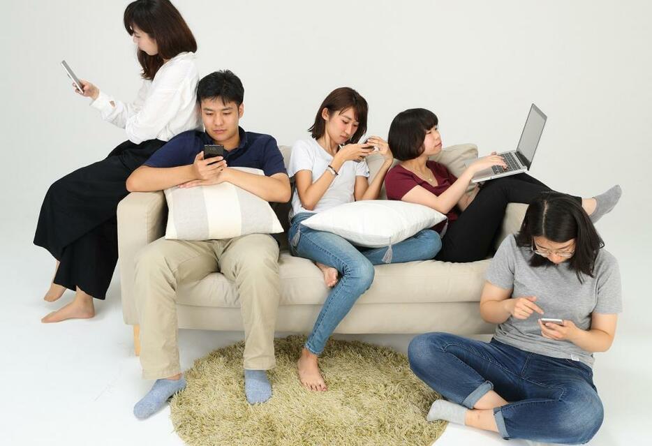 図3　ネットのチェックに追われる人たち（写真：アフロ）