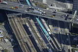 E5系「はやぶさ」の運転開始初日、「はやぶさ3号」とE2系が首都高速都心環状線の下ですれ違う。この頃は「上野東京ライン」の用地は整地されているが、まだ線路は敷かれていない。東京駅の引上げ線で211系が停車する（2011年3月5日、吉永陽一撮影）。