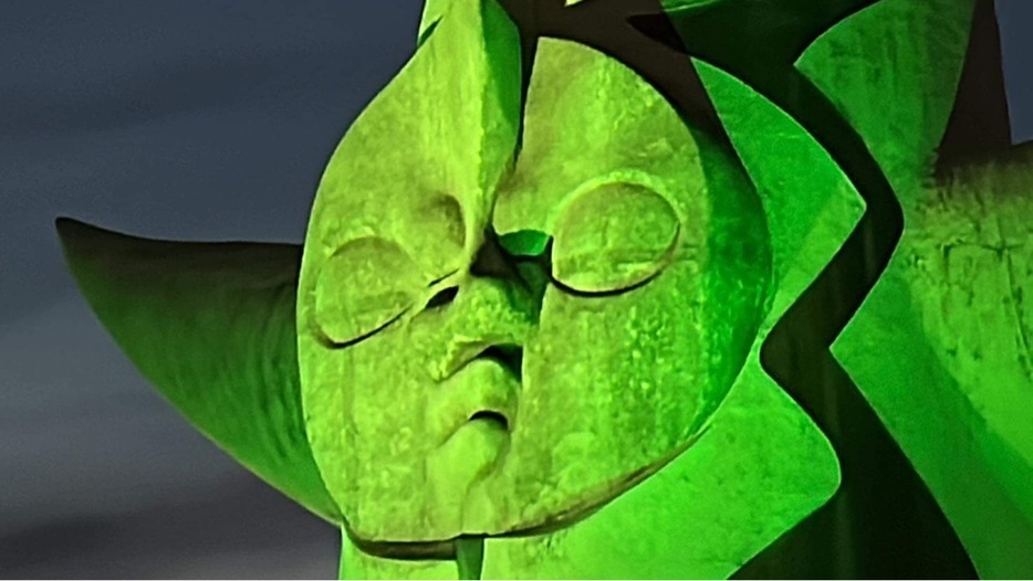 ［写真］太陽の塔の顔の部分も緑色に輝いていた＝23日夜、大阪府吹田市で