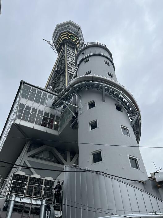 ［写真］通天閣のタワースライダーは3階中間展望台から地下1階まで円柱型のエレベーター棟に設置された60メートルの滑り台。工事関係者もはしごで登り確認する様子が見られた＝9日午前9時半ごろ、大阪市浪速区で