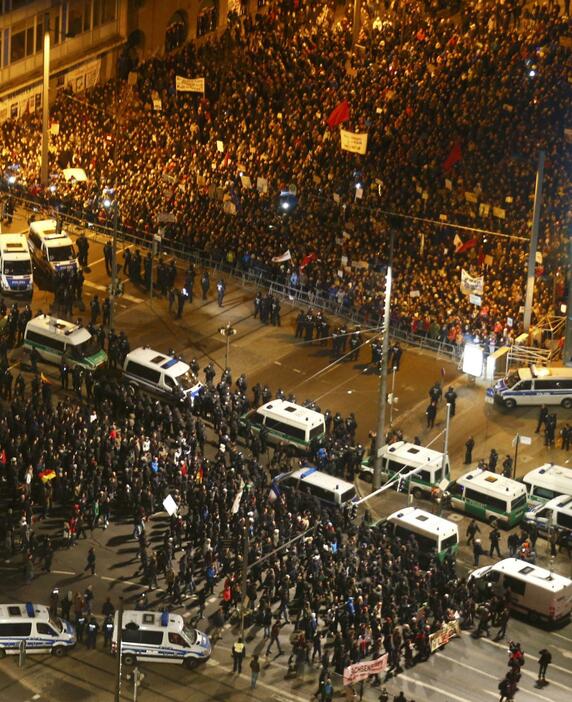ドイツで反移民デモが拡大。デモ参加者とデモ反対派が警察を挟みにらみ合い。＝1月21日（ロイター/アフロ）