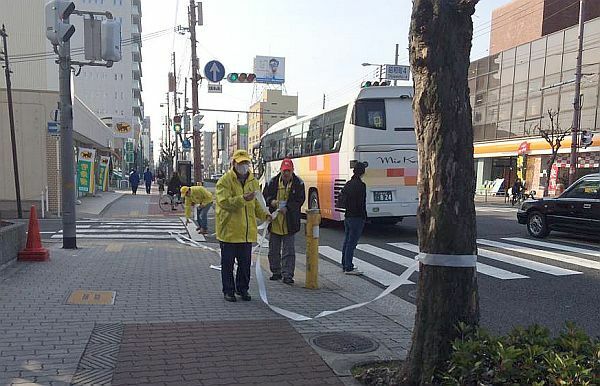 [写真]コース沿道の規制準備にかかるボランティア＝25日午前10時ごろ、大阪市阿倍野区で