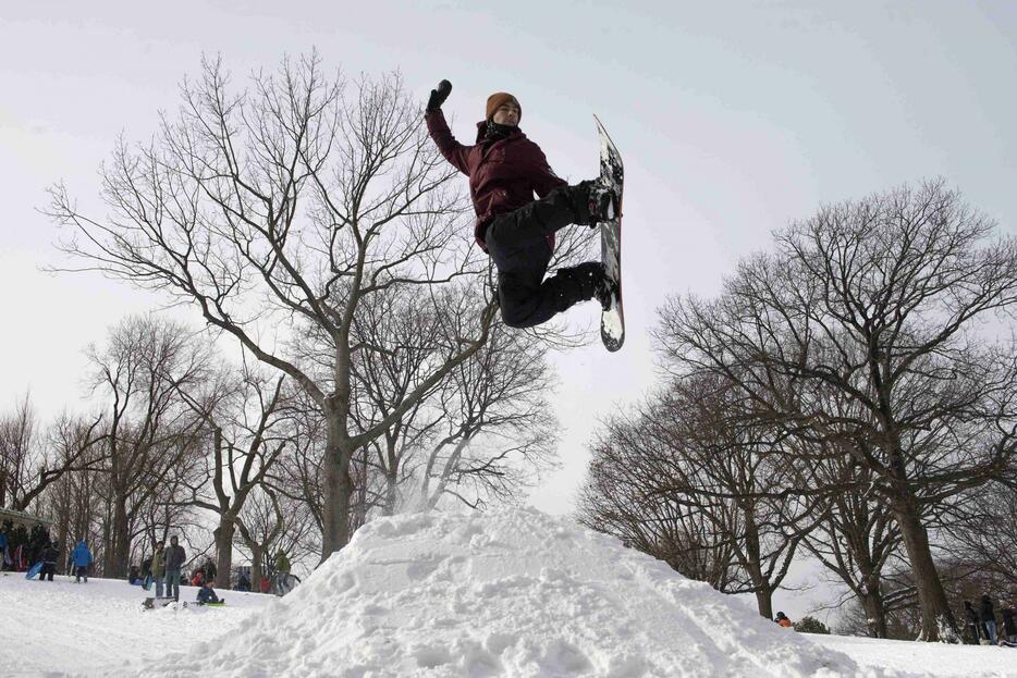 雪に見舞われたNYブルックリンのフォート・グリーン・パークでスノボ＝1月27日（ロイター/アフロ）