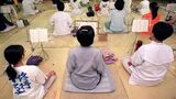 オウム真理教の道場で修行に励む信者たちの様子。教団内部の特殊な生活様式とマインドコントロールの環境を示唆する。