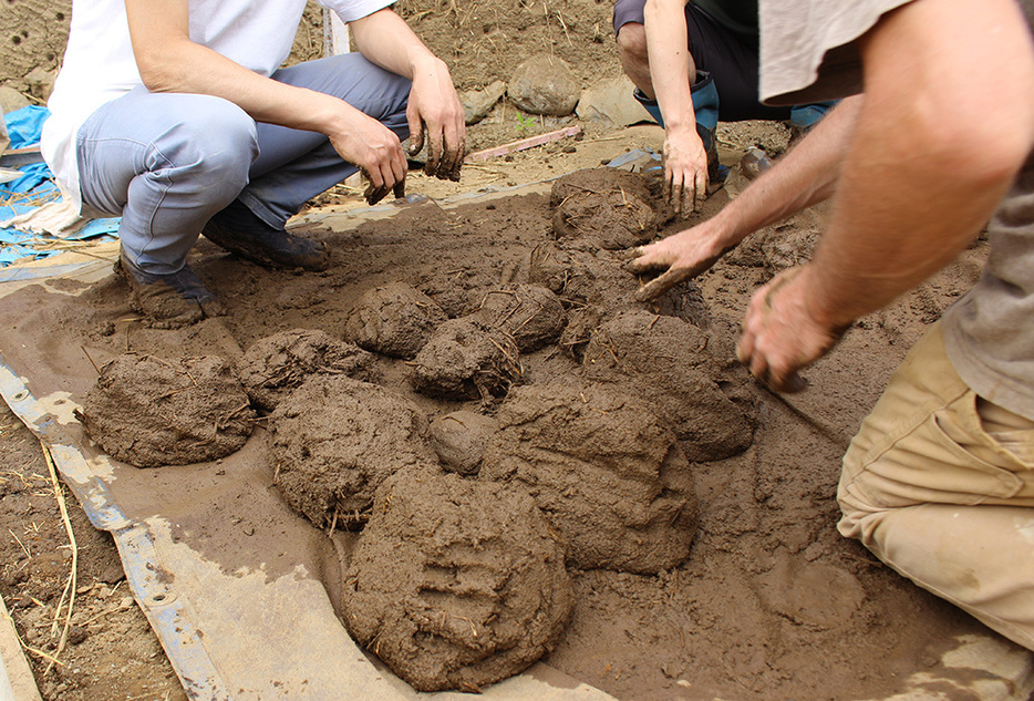 粘土と砂とワラを混ぜ、水でこねた土の団子を積み上げて分厚い壁を作る