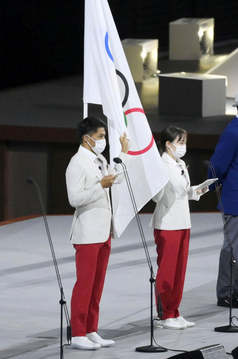 東京五輪開会式で選手宣誓する主将の山縣亮太（左）と副主将の石川佳純＝2021年7月、国立競技場