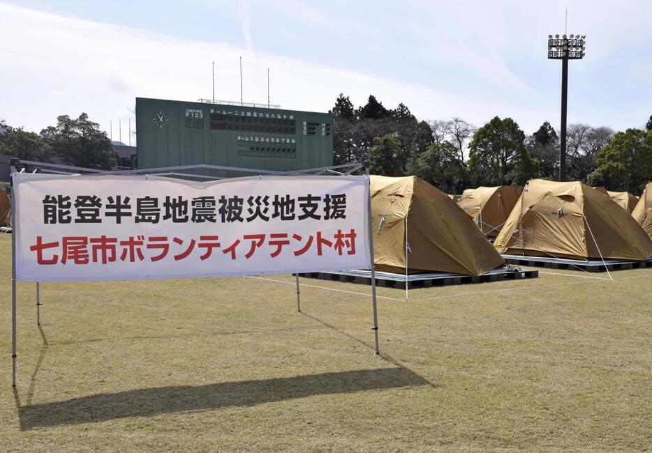 石川県七尾市の野球場に開設された、ボランティアが宿泊できるテント村＝24日午後