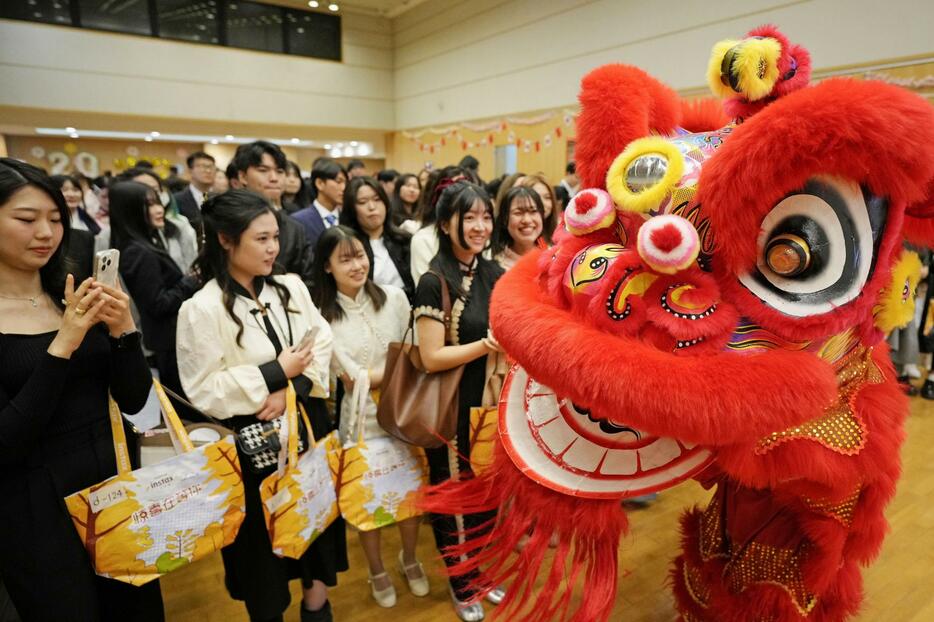 日本人留学生と中国人学生らの合同成人式で獅子舞の演舞を楽しむ新成人ら＝17日、北京の日本大使館（共同）