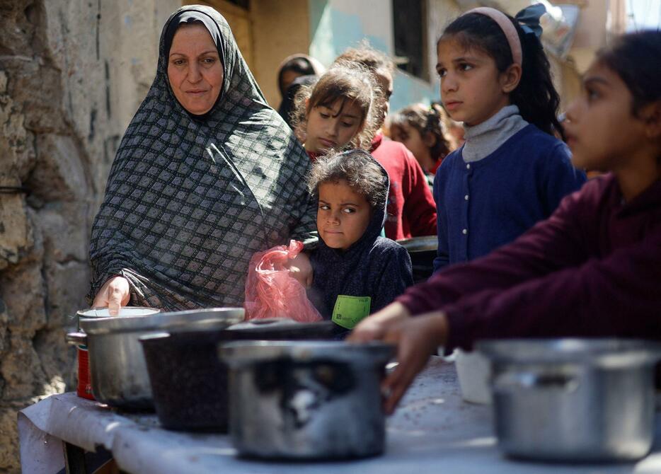 パレスチナ自治区ガザ南部ラファで食事を求める子どもら＝5日（ロイター＝共同）