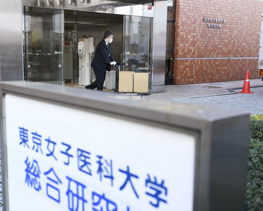 東京女子医大を家宅捜索し、押収物を運び出す警視庁の捜査員ら＝29日午後4時52分、東京都新宿区