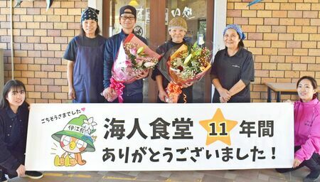 花束を手にする「海人食堂」の平安山良店長（左から３人目）とスタッフ＝１０日、伊江村・伊江港ターミナル