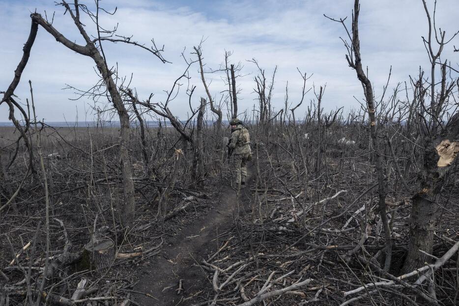 ウクライナ東部ドネツク州バフムト近郊の前線を歩くウクライナ兵＝18日（AP＝共同）