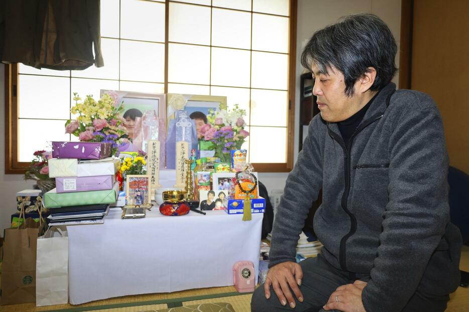 亡くなった妻裕美さんと長男啓徳君の遺影を見つめる角田貴仁さん＝2月、金沢市