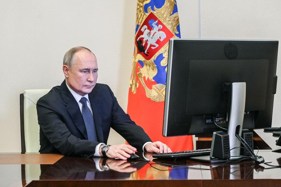 15日、モスクワ郊外の公邸でインターネット投票するロシアのプーチン大統領（ロシア大統領府提供・タス＝共同）