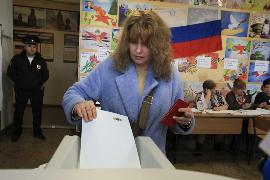 ロシアが実効支配するウクライナ南部クリミア半島のシンフェロポリで投票する女性＝15日（AP＝共同）