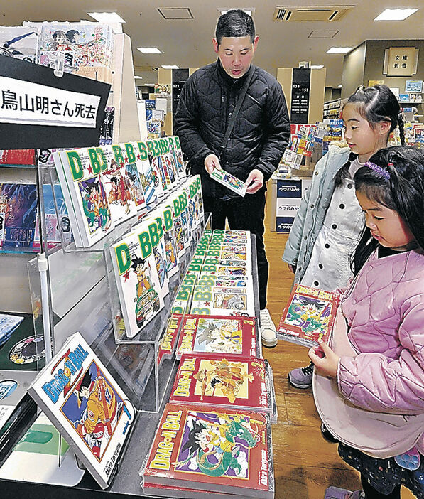 店内に設けられたコーナーで「ドラゴンボール」を手に取る親子連れ＝９日午前１１時半、金沢市内