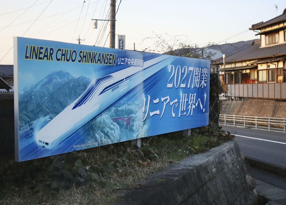 リニア中央新幹線の新駅の工事が進められている岐阜県中津川市に置かれた2027年開業を伝える看板＝29日午後