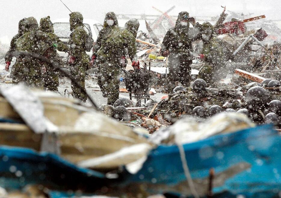 雪の中、行方不明者を捜索する自衛隊員＝2011年3月16日、宮城県南三陸町、西畑志朗撮影