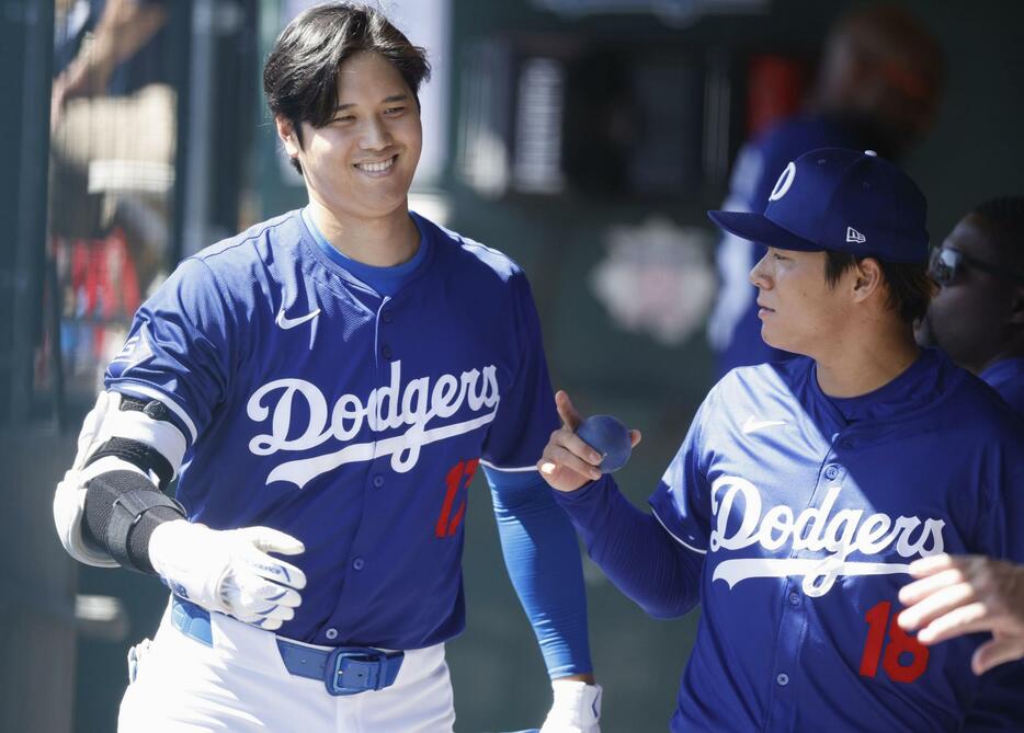 米大リーグ、マリナーズとのオープン戦のベンチで言葉を交わすドジャース・大谷翔平（左）と山本由伸＝13日、アリゾナ州グレンデール（共同）