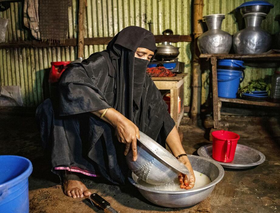 バングラデシュで家族の昼食の準備をするロヒンギャ難民の女性＝2023年10月（UNHCR提供・共同）