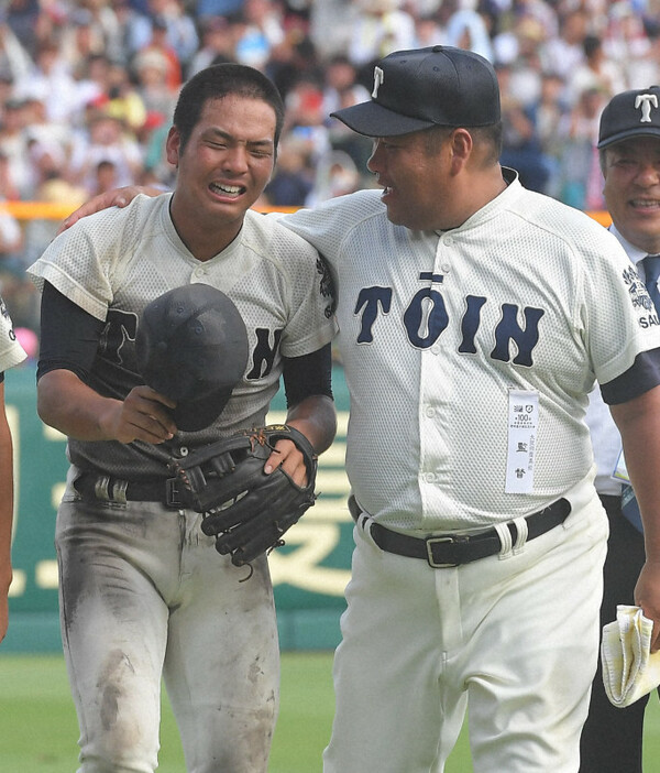 夏の甲子園で優勝し、アルプス席の応援団へのあいさつを終えて大阪桐蔭の西谷浩一監督（右）に肩を抱かれる中川卓也主将＝阪神甲子園球場で2018年8月21日、津村豊和撮影