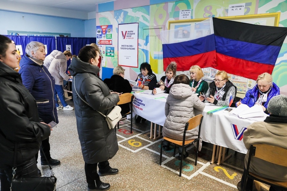 15日、ロシアが実効支配するウクライナ東部ドネツクで、大統領選の投票をする人々（タス＝共同）
