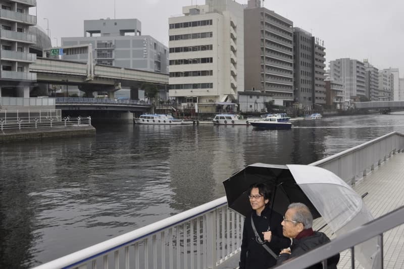 運河が多い芝浦地区を案内する芝浦１丁目町会の岡田祥男会長（左）＝２月