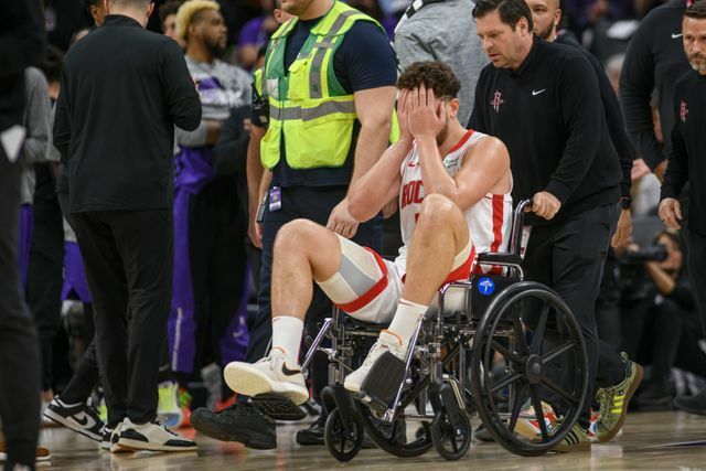 右足を負傷し車いすに乗せられコートを去るロケッツのシェングン選手(写真：AP/アフロ)