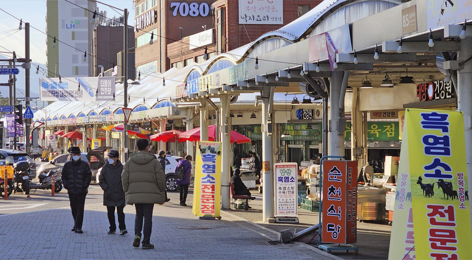 韓国・城南の牡丹市場。右端の看板は「黒ヤギ専門店」をうたう＝2024年1月（共同）