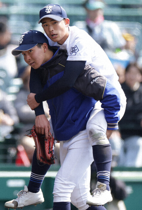 【宇治山田商－東海大福岡】六回裏、打球処理の際に負傷し、背負われてベンチに戻る宇治山田商の左翼手・郷＝阪神甲子園球場で2024年3月21日、中川祐一撮影