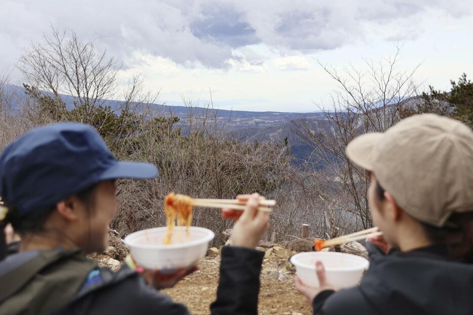 山梨県南部の山、パノラマ台で開かれた「山頂パスタ会」でパスタを食べる参加者ら＝20日午前