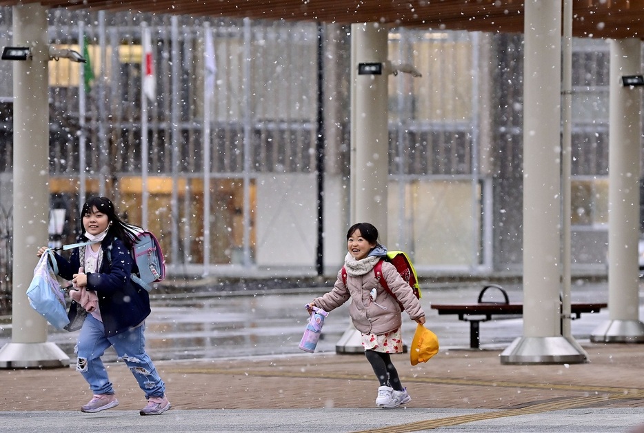 タクシーで小学校から到着後、雪を見て嬉しそうに駆け出す長女さよりちゃん（右）＝2月5日、福島県双葉町