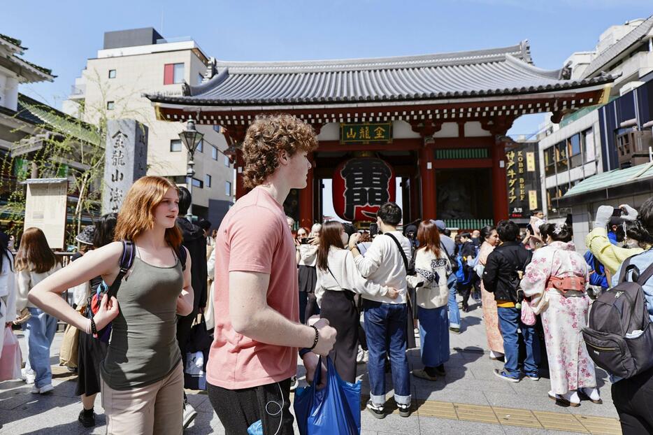 半袖姿で東京・浅草寺の雷門前を歩く人たち＝30日午後