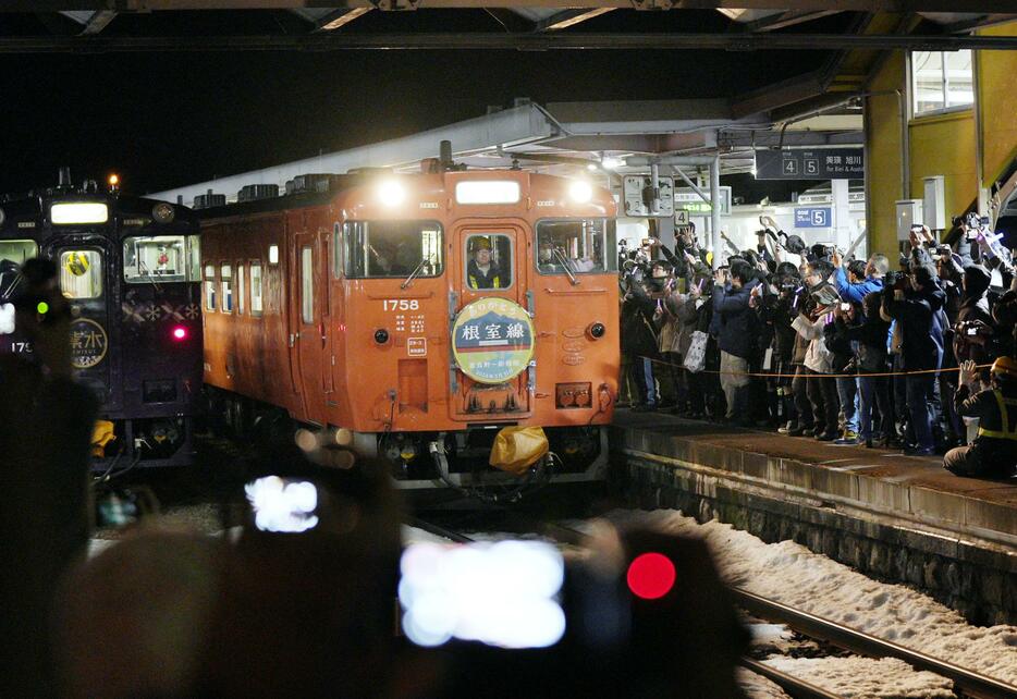 JR北海道の根室線富良野―新得間の最終運行日を迎え、大勢の人に見送られるJR富良野駅発の最終列車（右）＝31日夜