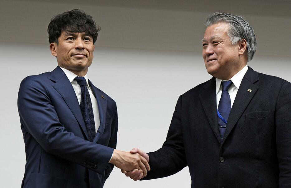 任期を終えた田嶋幸三会長（右）と写真に納まる日本サッカー協会の宮本恒靖新会長＝23日、東京都文京区