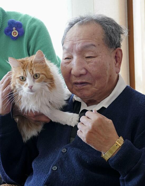 浜松市の自宅で、保護猫とふれあう袴田巌さん＝2月