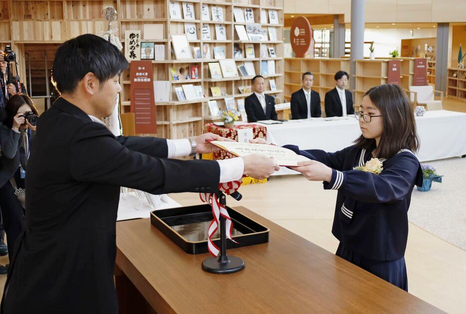 義務教育学校「学び舎ゆめの森」で開かれた卒業式で、卒業証書を受け取る生徒＝13日午前、福島県大熊町