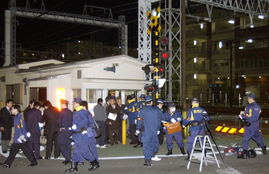 事故が起きた東武伊勢崎線竹ノ塚駅近くの踏切付近を調べる捜査員ら＝2005年3月、東京都足立区