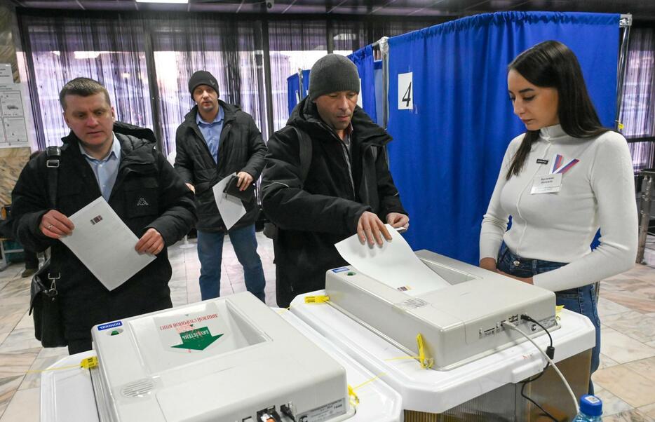 15日、ロシア極東チタで投票する男性ら（タス＝共同）